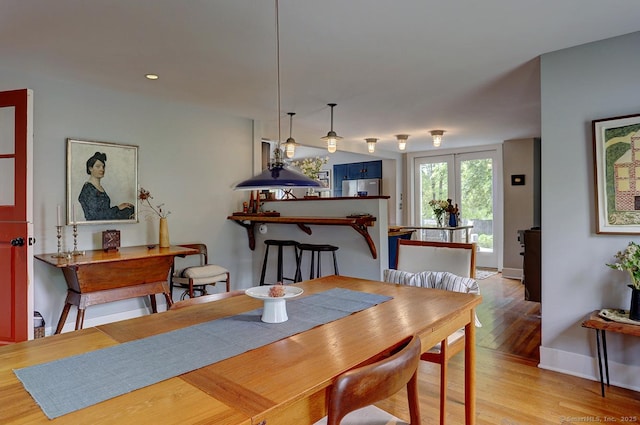 dining space featuring light wood-style floors, baseboards, and recessed lighting