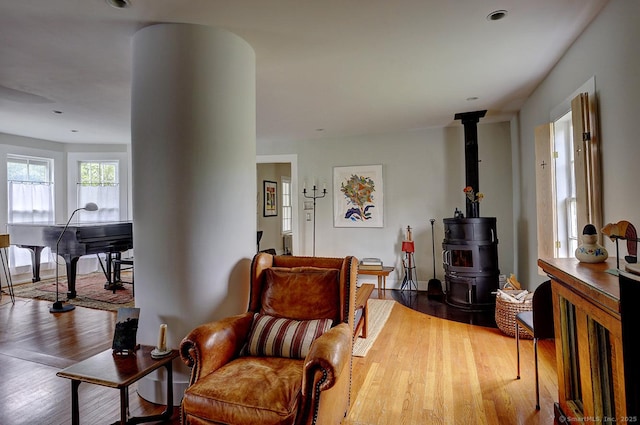 living room featuring a wood stove, wood finished floors, and recessed lighting