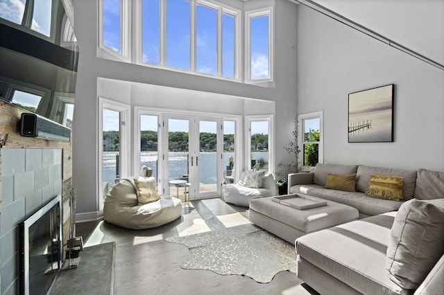 233 Front St Unit 3, New Haven, CT 06513 - living room with a fireplace with raised hearth, a towering ceiling, wood finished floors, a water view, and french doors