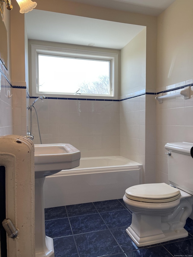 674 Williams St, New London, CT 06320 - bathroom with tile walls, a bath, toilet, a wainscoted wall, and tile patterned floors