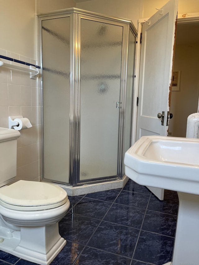 674 Williams St, New London, CT 06320 - bathroom featuring toilet, a stall shower, marble look tiles, and tile walls