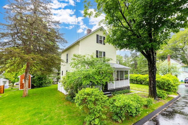 2 Middle Ln, Simsbury, CT 06070 - view of home's exterior featuring a sunroom, a chimney, a lawn, and an outdoor structure
