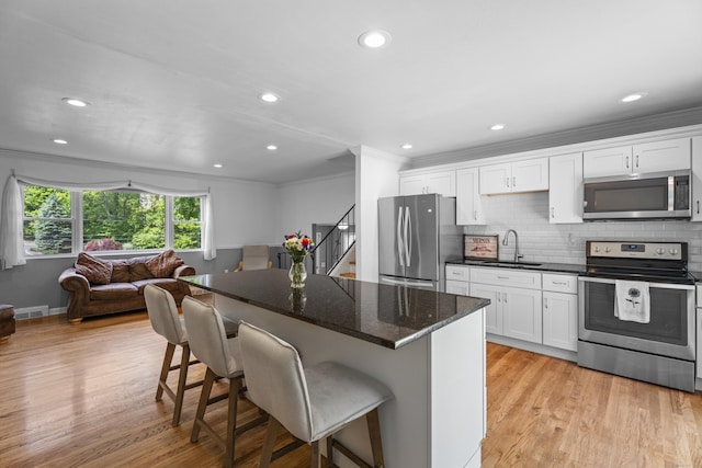 15 Ridgewood Dr, Monroe, CT 06468 - kitchen with stainless steel appliances, a sink, crown molding, a kitchen bar, and white cabinets