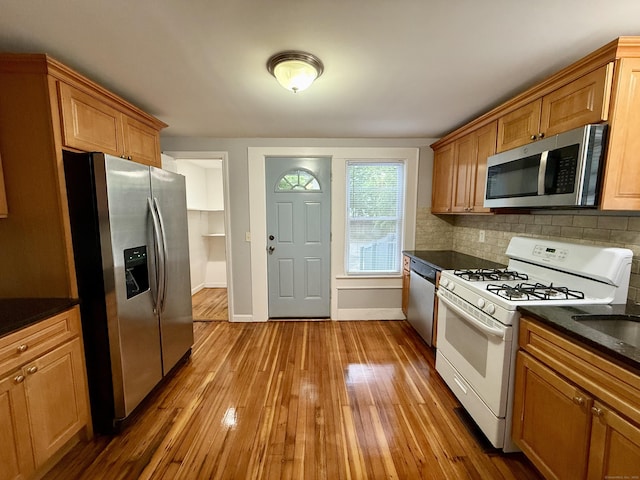 16-1/2 W Main St, Norwalk, CT 06851 - kitchen featuring appliances with stainless steel finishes, dark countertops, hardwood / wood-style flooring, decorative backsplash, and baseboards