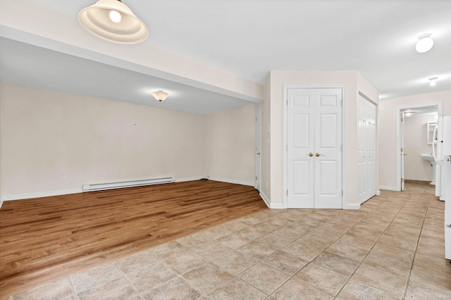 2 Lakeview Cir E, Lyme, CT 06357 - basement featuring a baseboard radiator, baseboards, and light wood finished floors