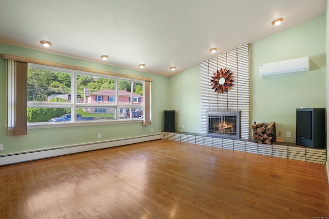 101 Rosengarten Dr, Waterbury, CT 06704 - unfurnished living room with a baseboard heating unit, a wall mounted AC, wood finished floors, a tiled fireplace, and lofted ceiling