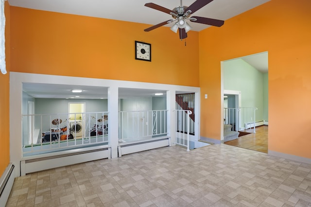 101 Rosengarten Dr, Waterbury, CT 06704 - spare room featuring a high ceiling, baseboard heating, separate washer and dryer, a ceiling fan, and stairs