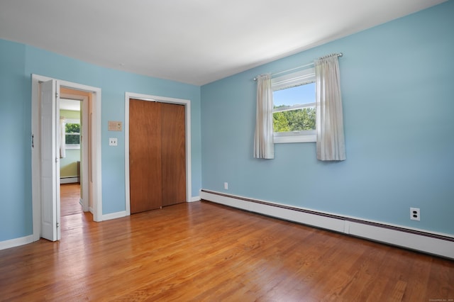 101 Rosengarten Dr, Waterbury, CT 06704 - unfurnished bedroom featuring a baseboard radiator, light wood finished floors, a closet, and baseboards