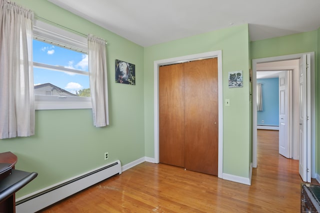 101 Rosengarten Dr, Waterbury, CT 06704 - unfurnished bedroom with a baseboard radiator, light wood-style flooring, and baseboards