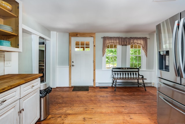 538 Scotland Rd, Norwich, CT 06360 - kitchen with stainless steel fridge, a baseboard radiator, wooden counters, white cabinetry, and wood finished floors