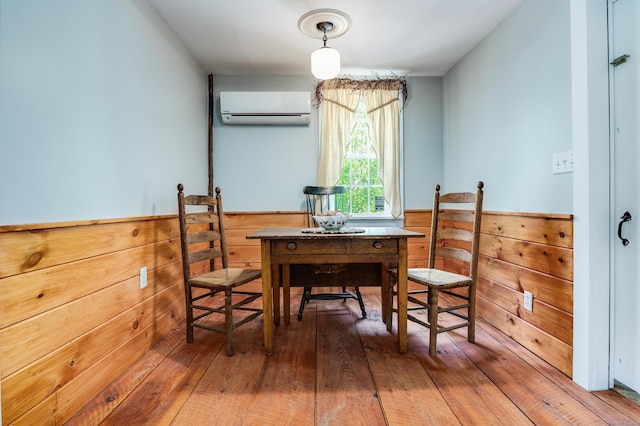 538 Scotland Rd, Norwich, CT 06360 - dining room with a wall mounted AC, wainscoting, wooden walls, and wood-type flooring