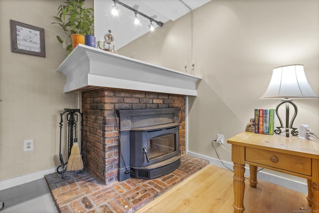 9 Lower Commons Unit 9, Woodbury, CT 06798 - detailed view of track lighting, baseboards, a wood stove, and wood finished floors