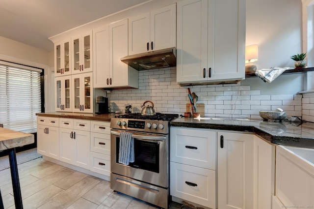 21 Elm St, Southington, CT 06479 - kitchen featuring stainless steel range with gas stovetop, under cabinet range hood, white cabinets, decorative backsplash, and glass insert cabinets