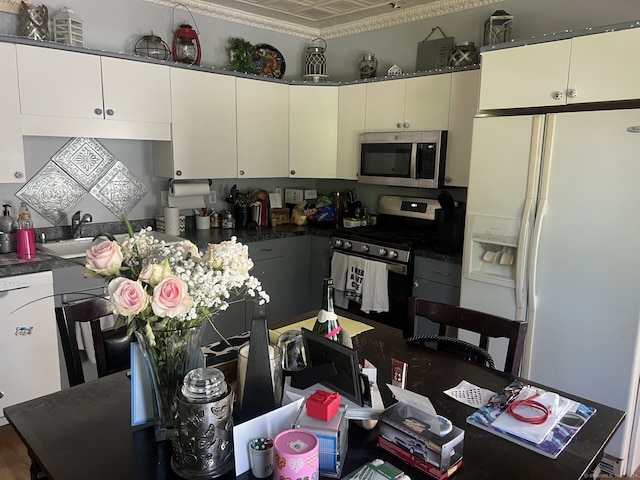 66 Seymour Ave, Derby, CT 06418 - kitchen with stainless steel appliances, a sink, white cabinetry, an ornate ceiling, and dark countertops