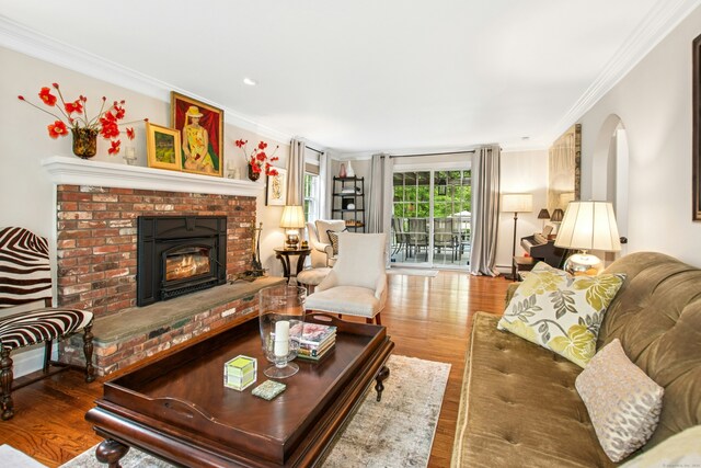 19 Pheasant Ridge Rd, Redding, CT 06896 - living room with crown molding, wood finished floors, a brick fireplace, and arched walkways