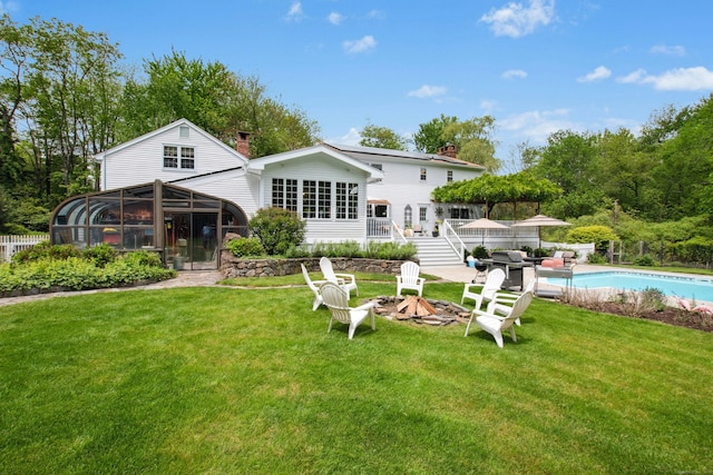 19 Pheasant Ridge Rd, Redding, CT 06896 - back of house with a chimney, an outdoor fire pit, an outdoor pool, and a lawn