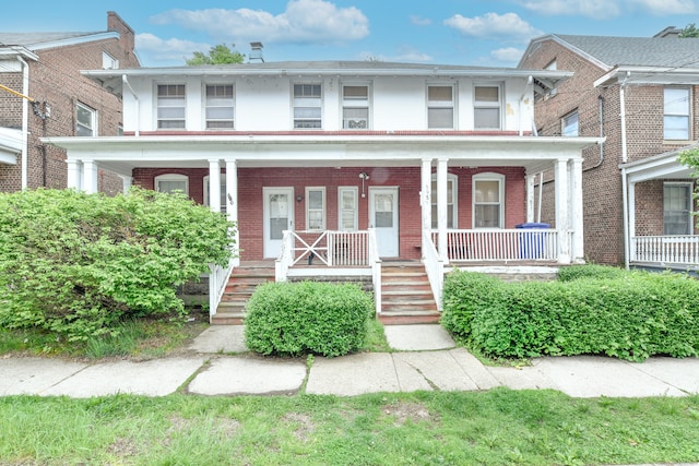 400 E Ave, Bridgeport, CT 06610 - american foursquare style home featuring brick siding, stucco siding, and a porch