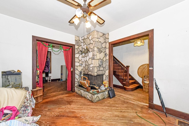 400 E Ave, Bridgeport, CT 06610 - living room with ceiling fan, wood finished floors, a stone fireplace, and stairway