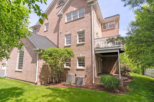 2 Governors Row Unit 2, West Hartford, CT 06117 - back of house with a lawn, central AC, brick siding, and a balcony