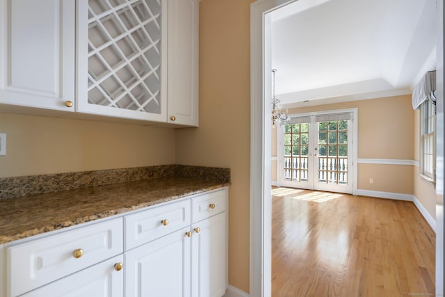 2 Governors Row Unit 2, West Hartford, CT 06117 - bar with light wood-style flooring, baseboards, a chandelier, and french doors