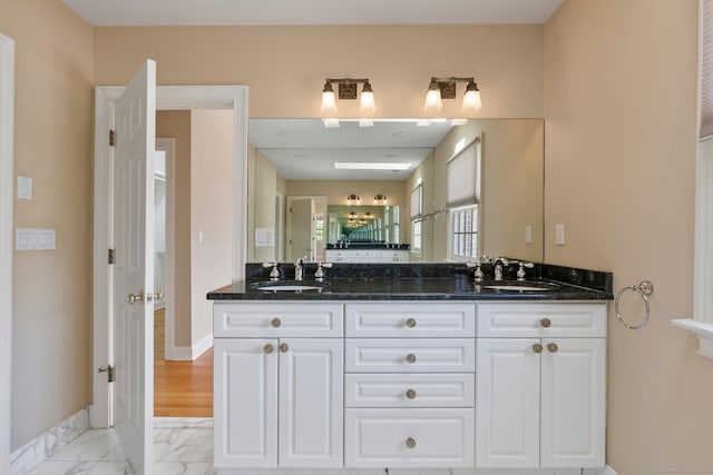 2 Governors Row Unit 2, West Hartford, CT 06117 - bathroom featuring marble look tiles, double vanity, and baseboards