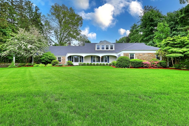 691 Buttonball Rd, Orange, CT 06477 - view of front of house featuring stone siding, a front lawn, a chimney, and roof with shingles