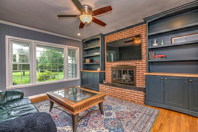 691 Buttonball Rd, Orange, CT 06477 - living area with light wood-style floors, ceiling fan, ornamental molding, a fireplace, and built in features
