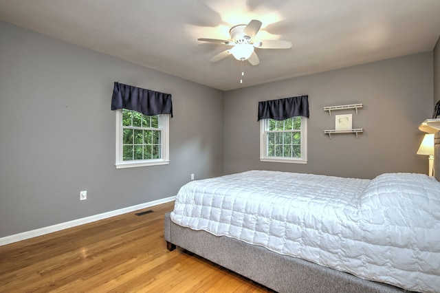 691 Buttonball Rd, Orange, CT 06477 - bedroom featuring multiple windows, baseboards, wood finished floors, and ceiling fan