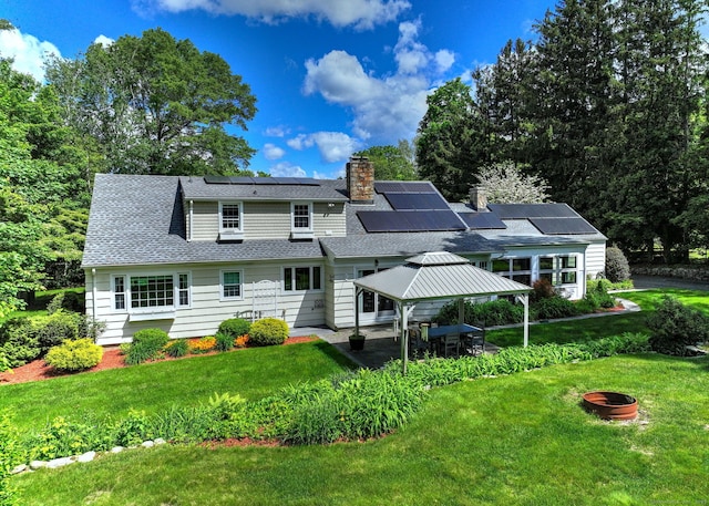 691 Buttonball Rd, Orange, CT 06477 - rear view of property with a gazebo, roof mounted solar panels, a chimney, a yard, and roof with shingles