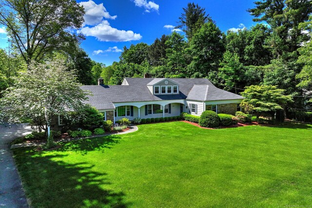 691 Buttonball Rd, Orange, CT 06477 - view of front of house featuring a front yard, a chimney, and stone siding