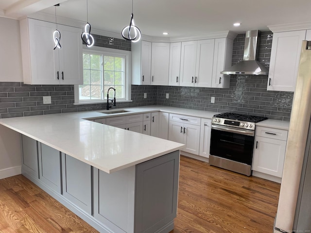 285 Alba Ave, Bridgeport, CT 06606 - kitchen with wall chimney exhaust hood, gas range, a peninsula, light wood-type flooring, and light countertops
