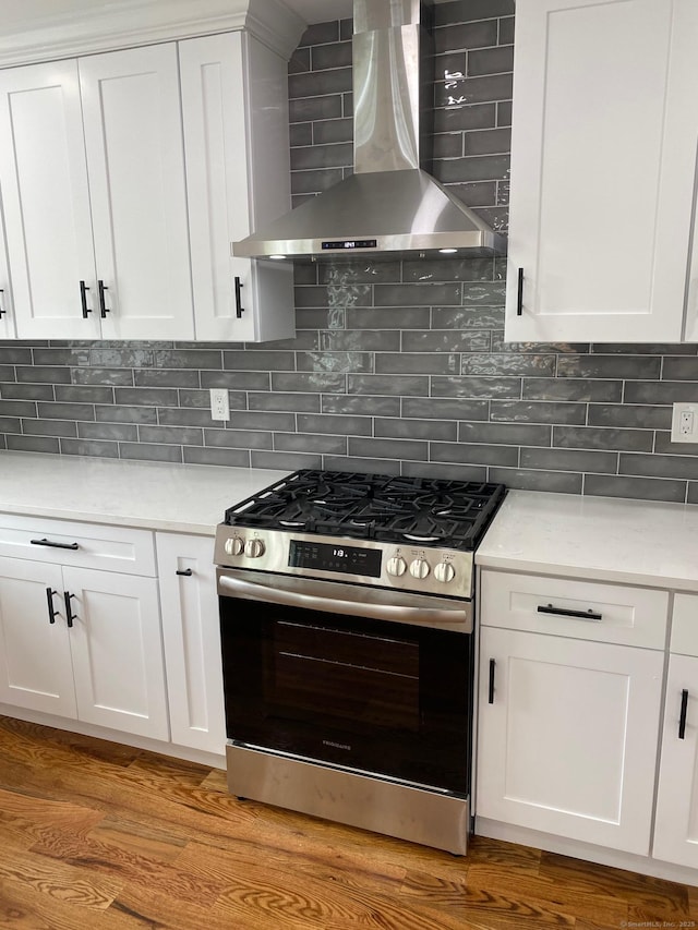 285 Alba Ave, Bridgeport, CT 06606 - kitchen with stainless steel range with gas cooktop, wall chimney exhaust hood, light wood-style flooring, light countertops, and white cabinets