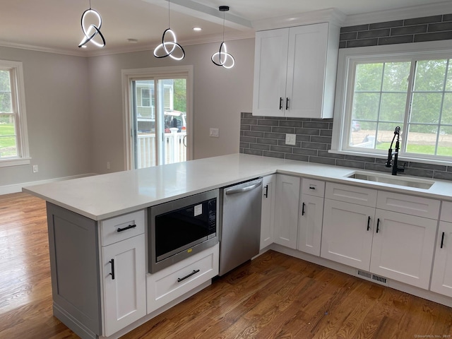 285 Alba Ave, Bridgeport, CT 06606 - kitchen with stainless steel appliances, crown molding, a peninsula, light countertops, and wood finished floors