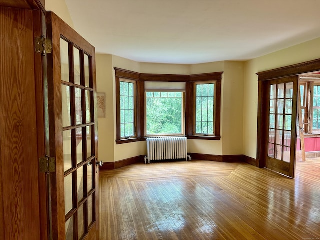 1666 Ridge Rd, North Haven, CT 06473 - spare room with radiator heating unit, french doors, and wood finished floors