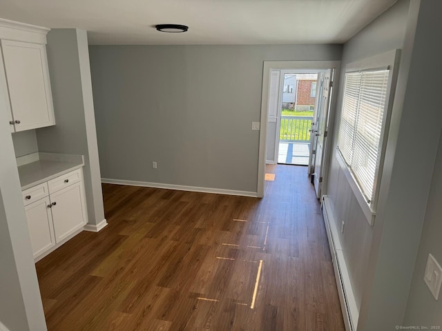 187 Jewett Ave, Bridgeport, CT 06606 - unfurnished dining area featuring a baseboard radiator, dark wood-style floors, and baseboards