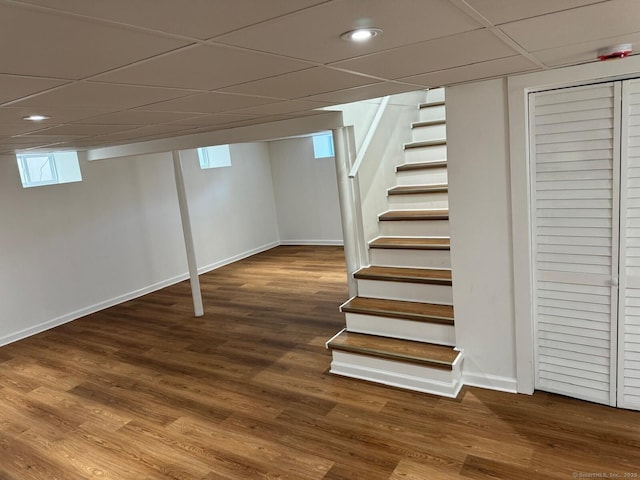 187 Jewett Ave, Bridgeport, CT 06606 - below grade area with baseboards, stairway, wood finished floors, recessed lighting, and a paneled ceiling