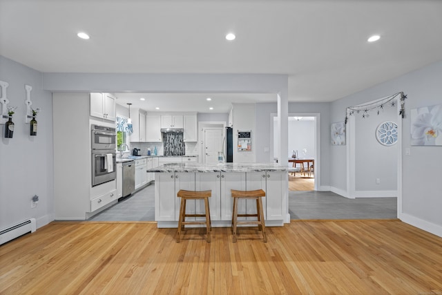 21 Corrina Ln, Salem, CT 06420 - kitchen featuring light wood finished floors, a kitchen bar, stainless steel appliances, white cabinetry, and a center island