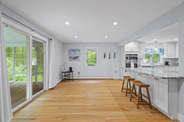 21 Corrina Ln, Salem, CT 06420 - kitchen with stainless steel double oven, plenty of natural light, a kitchen bar, white cabinetry, and recessed lighting