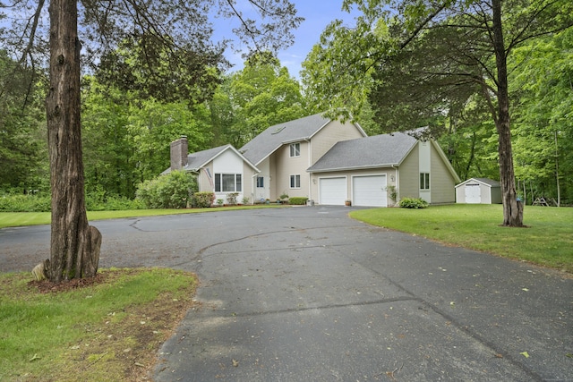 21 Corrina Ln, Salem, CT 06420 - view of front of property with asphalt driveway, a garage, a front yard, a chimney, and view of wooded area
