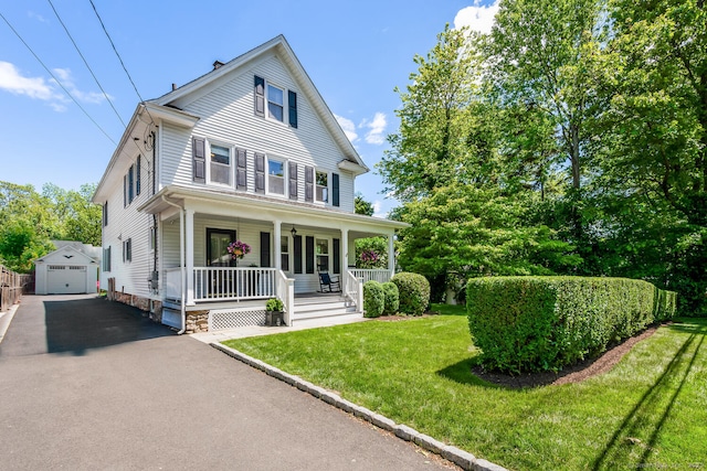 10 Fairfield Ave, Darien, CT 06820 - view of front facade with an outdoor structure, covered porch, asphalt driveway, a garage, and a front yard