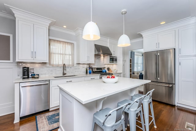 10 Fairfield Ave, Darien, CT 06820 - kitchen featuring appliances with stainless steel finishes, a sink, ornamental molding, wall chimney range hood, and white cabinetry