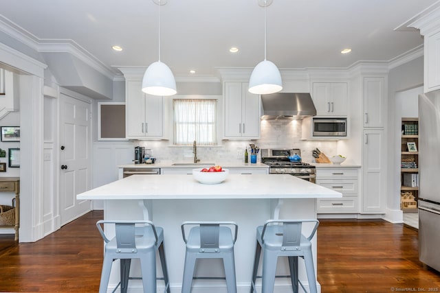 10 Fairfield Ave, Darien, CT 06820 - kitchen with stainless steel appliances, ventilation hood, a sink, dark wood-type flooring, and a breakfast bar