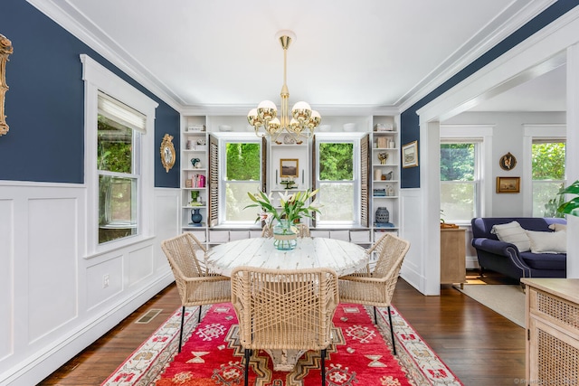 10 Fairfield Ave, Darien, CT 06820 - dining area featuring a chandelier, ornamental molding, built in features, wainscoting, and dark wood-type flooring