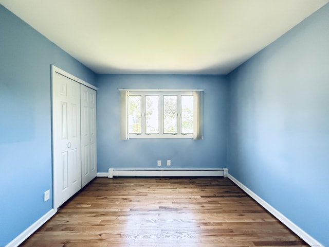 12 Rolling Ln, Norwalk, CT 06851 - unfurnished bedroom with baseboard heating, a closet, wood finished floors, and baseboards