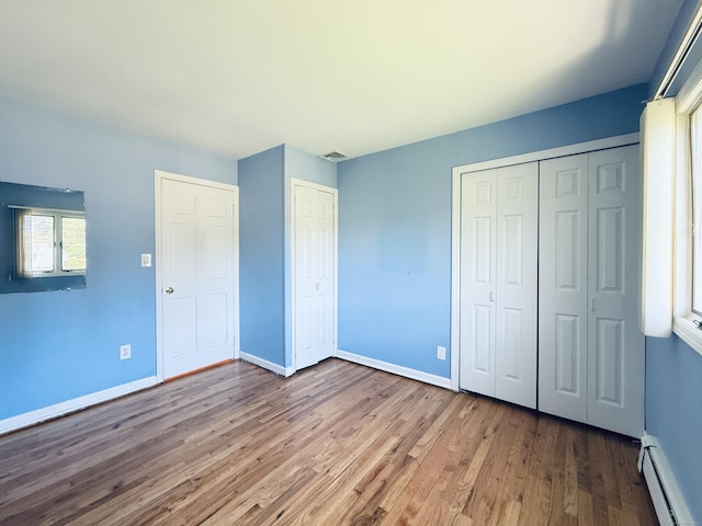 12 Rolling Ln, Norwalk, CT 06851 - unfurnished bedroom with baseboard heating, wood finished floors, and baseboards