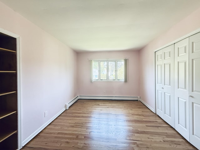 12 Rolling Ln, Norwalk, CT 06851 - unfurnished bedroom with wood finished floors, a baseboard radiator, a closet, and baseboards