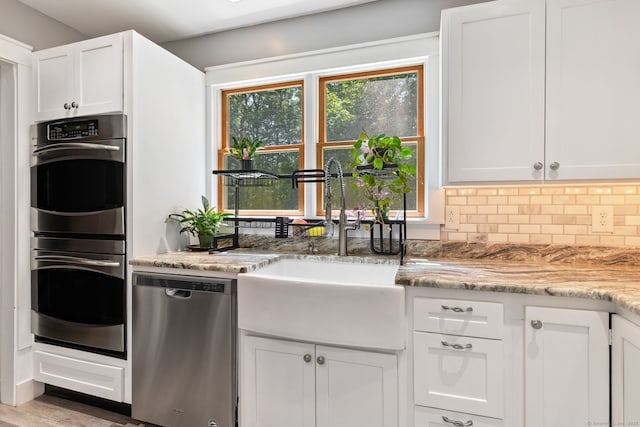 254 Haley Rd, Groton, CT 06355 - kitchen featuring appliances with stainless steel finishes, white cabinets, backsplash, and light stone countertops