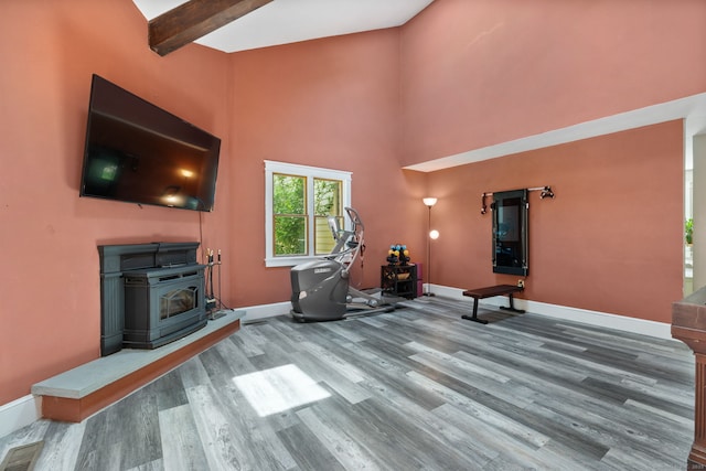254 Haley Rd, Groton, CT 06355 - unfurnished living room with wood finished floors, a wood stove, a high ceiling, and beam ceiling