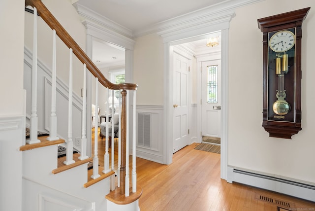 129 Brookmere Dr, Fairfield, CT 06824 - entrance foyer with a baseboard heating unit, stairway, light wood-style floors, a decorative wall, and ornamental molding