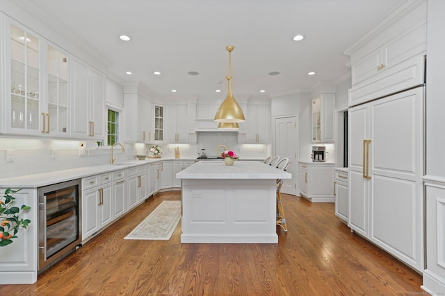 13 Witch Ln, Norwalk, CT 06853 - kitchen with beverage cooler, a sink, a kitchen island, white cabinetry, and backsplash